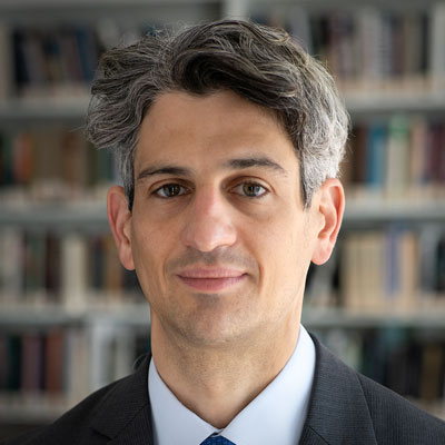 Samuel Charap in a suit standing in front of a brick wall